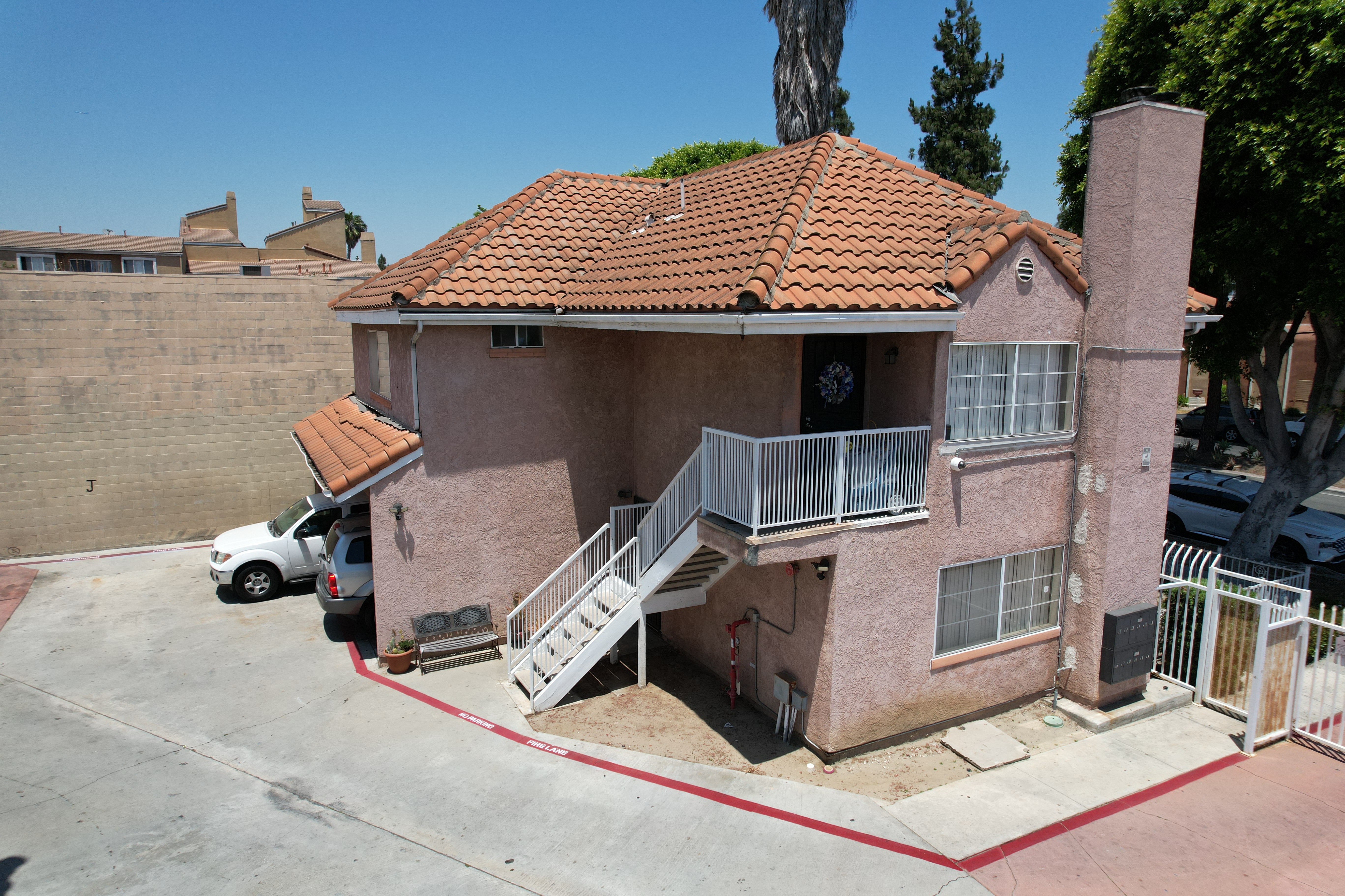 A house with a red tile roof and a white car parked in front.